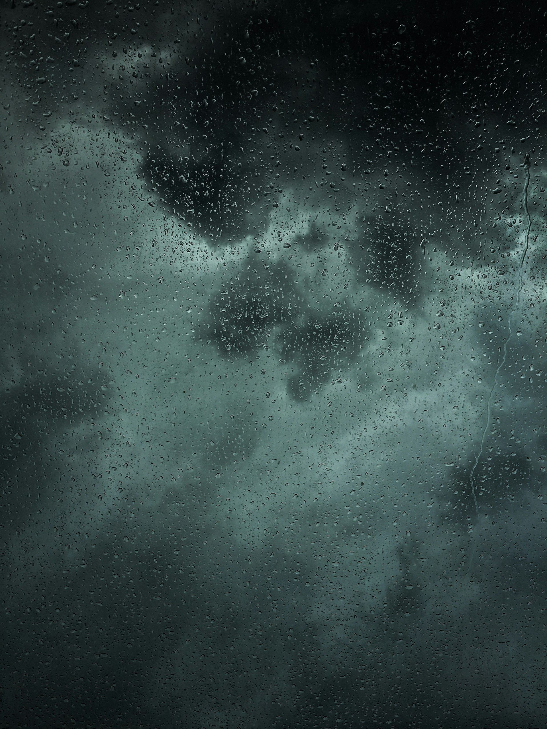 Rain falling against a dark window at night